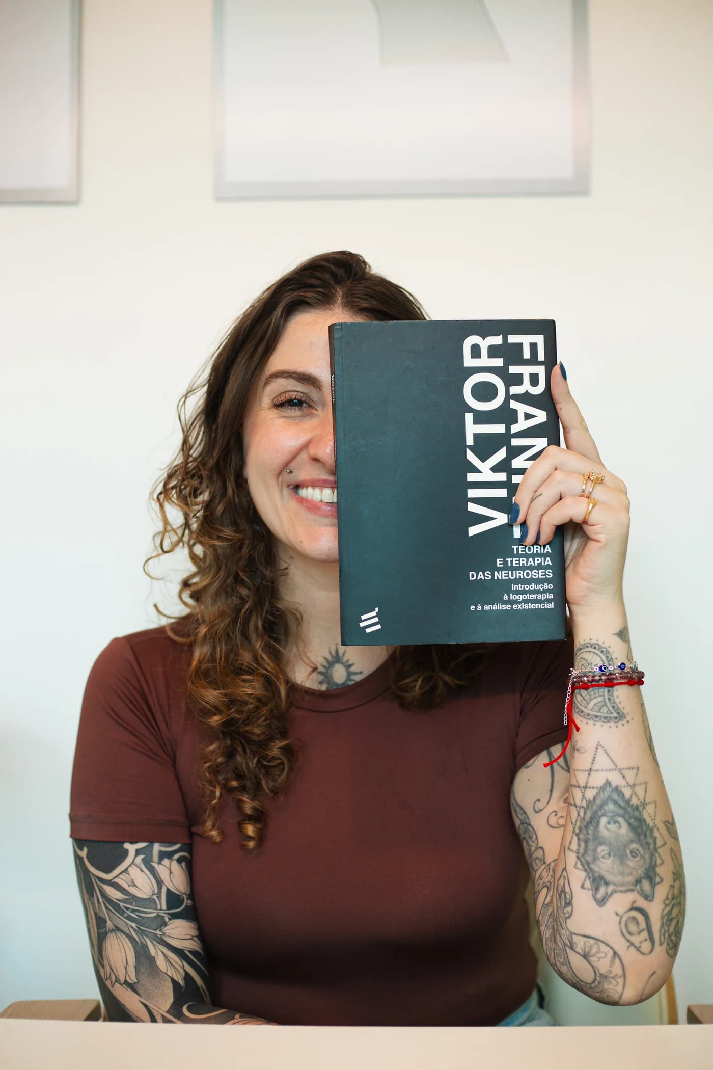 Gabriela Almeida segurando um livro de Viktor Frankl sobre Logoterapia